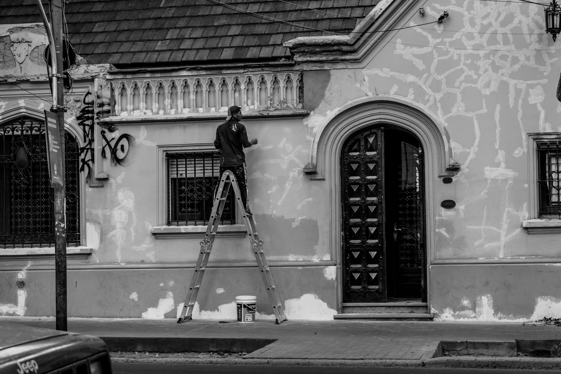Black and white photo of a man painting a historic building in Riverside, CA